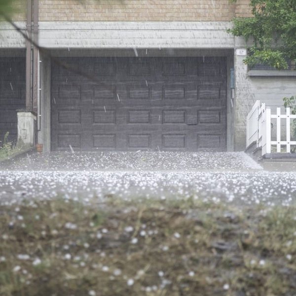 Rainy day with hailstones on driveway.