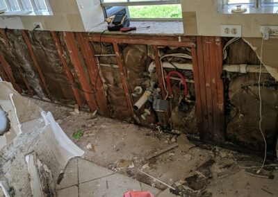 Kitchen demolition and exposed wall with plumbing.