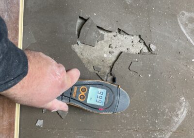 Person testing floor durability with device.