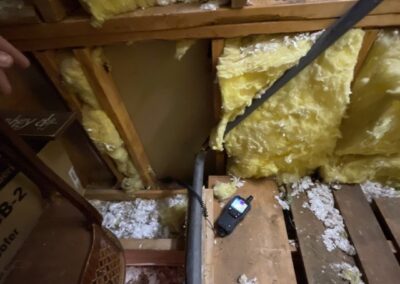 Insulation in attic, floor joists, walkie-talkie, wooden planks.