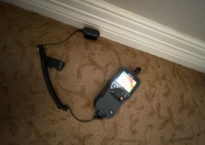 Handheld walkie-talkie on carpeted floor.