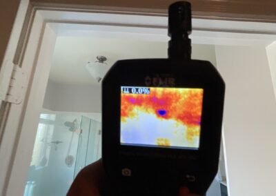 Hand holding thermal camera indoors.